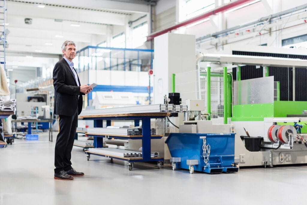 Manager with tablet in production hall